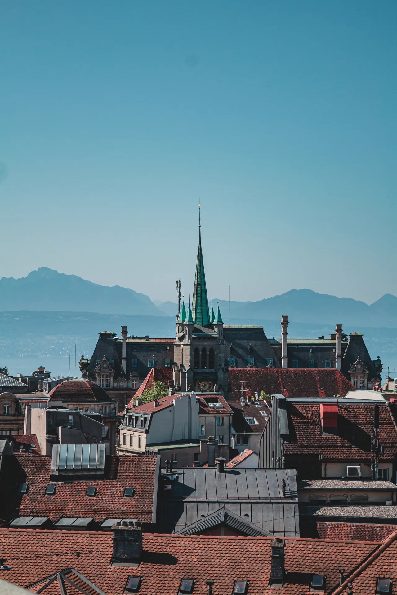 Les toits de Lausanne et la flèche de la cathédrale, les Alpes en arrière-plan.